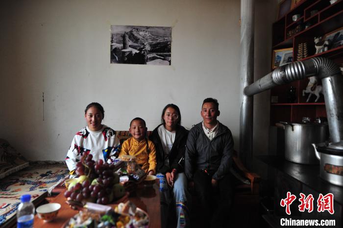 圖為8月12日，2018年7月從距那曲市色尼區(qū)城區(qū)那曲鎮(zhèn)90千米外的古露鎮(zhèn)當(dāng)桑村搬遷至城區(qū)的旦增(右一)與家人在80多平方米的新家合影(資料圖)。　張偉 攝