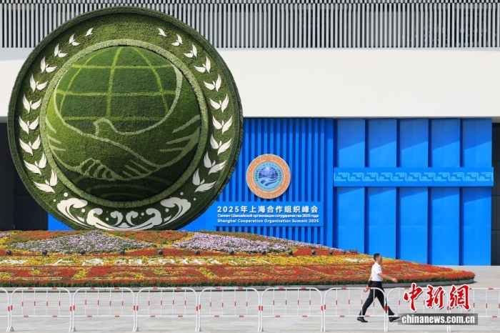 8月31日，天津，一名工作人員從2025年上海合作組織峰會主會場外的景觀花壇旁經(jīng)過。當(dāng)日，2025年上海合作組織峰會在天津舉行。<a target='_blank' href='/'><p  align=