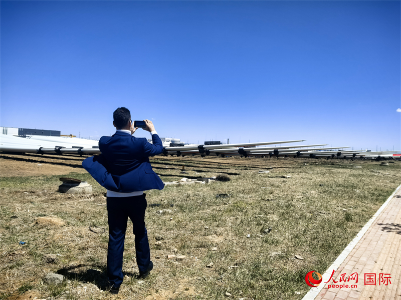 外媒記者拍攝廠房外的風(fēng)力渦輪發(fā)電機(jī)的巨型漿葉。人民網(wǎng) 楊春燕攝