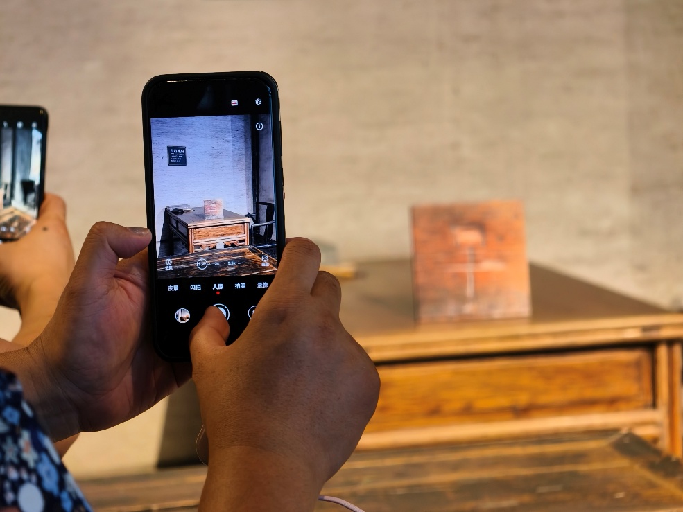 2025年7月15日，暑期研學(xué)團(tuán)小朋友在浙江省紹興市三味書屋拍攝魯迅讀書座位及課桌上的“早”字。受訪者供圖