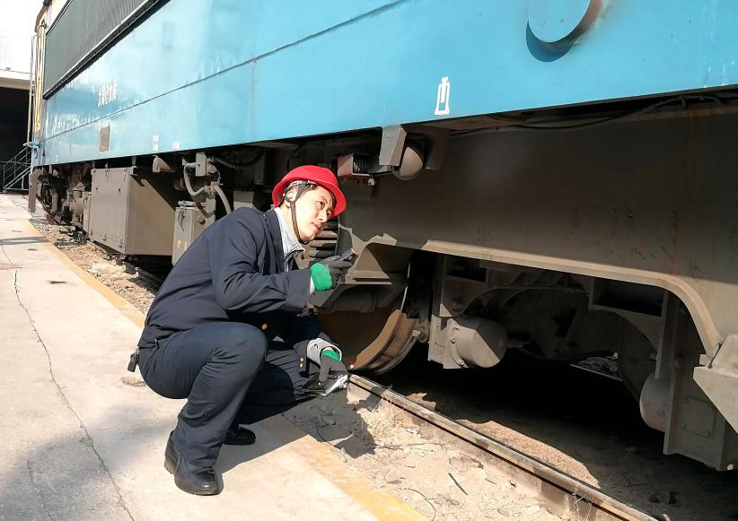 韓文盛全神貫注檢查機(jī)車走行部。