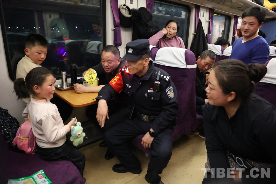 乘警長左紅彬在巡視車廂間隙，向攜帶兒童的旅客專門叮囑安全注意事項。.JPG