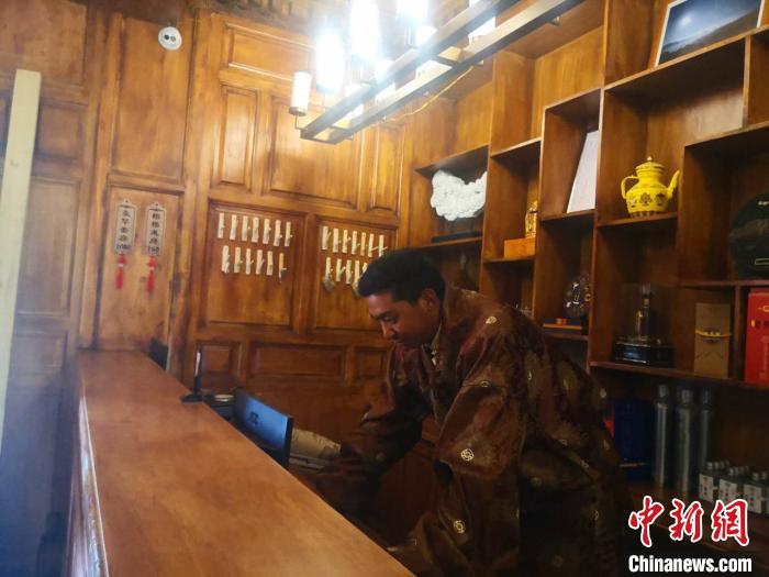 圖為桑杰才讓用電腦處理財務?！∈缝o靜 攝