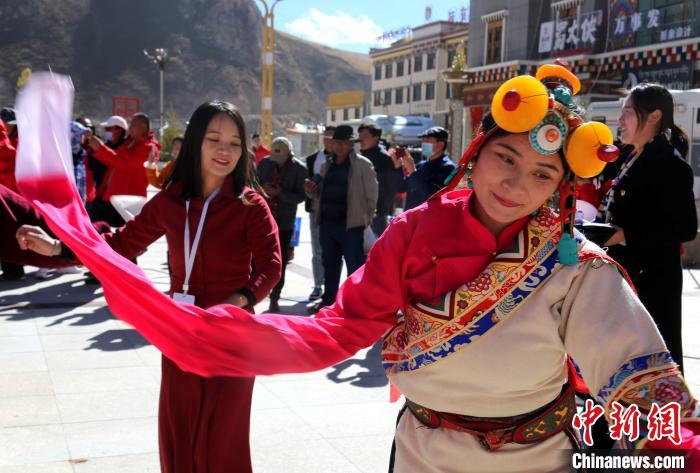 圖為中外記者向當地民眾學習民族歌舞文化?！?zhí)砀?攝