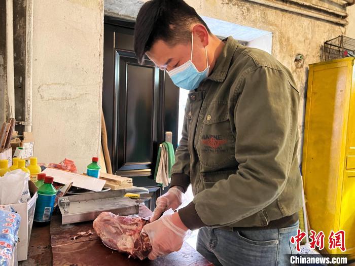 圖為雪豹“奶爸”史壽軍正在準(zhǔn)備投喂雪豹的食材?！●R銘言 攝