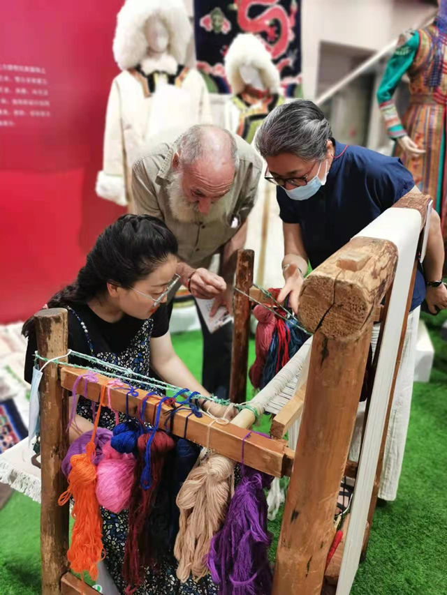 楊永良的學(xué)生在展會(huì)上向客商介紹加牙藏毯編織技藝。受訪者供圖