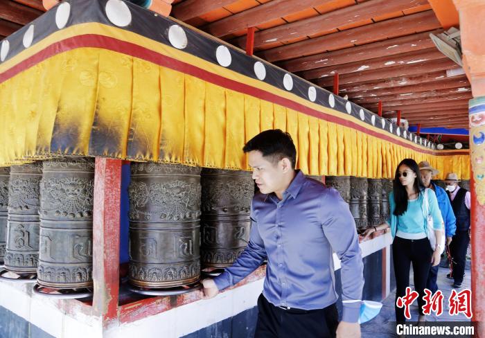 圖為外籍嘉賓體驗(yàn)藏族傳統(tǒng)轉(zhuǎn)經(jīng)筒?！●R銘言 攝