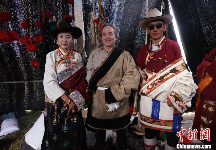 圖為一名外籍?dāng)z影師(中)身穿藏服和藏族民眾合影留念。　馬銘言 攝