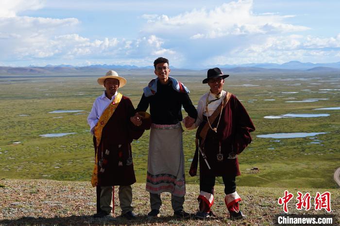 圖為一名留學(xué)生身穿自己國家的服飾和藏族民眾合影留念?！●R銘言 攝