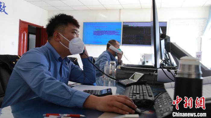 圖為貨運調度人員與外勤工作人員聯(lián)系掌握車輛裝載情況?！±钌?攝