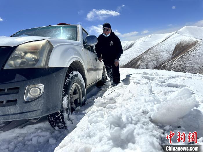 圖為生態(tài)管護人員準備在雪地推車?！《“瓦_杰 攝