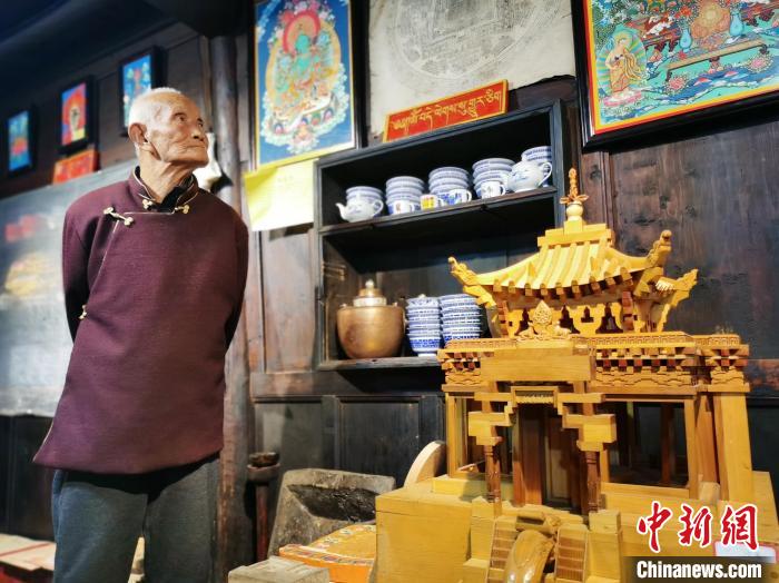 圖為古堡內(nèi)的藝人桑杰展示自己的雕刻作品。　張?zhí)砀?攝