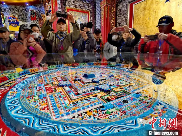 圖為參觀者拍攝壇城?！?zhí)砀?攝