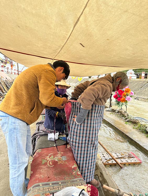 扎西奪爾登為路邊老人送去保暖圍腰。阿壩州文明辦供圖