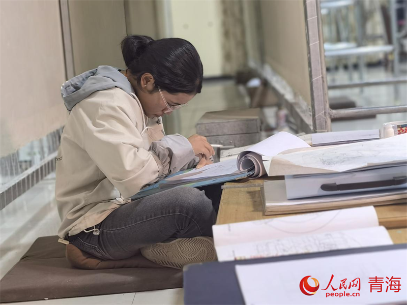 正在學(xué)習(xí)畫底稿的尕讓旺姆。人民網(wǎng) 陳明菊攝