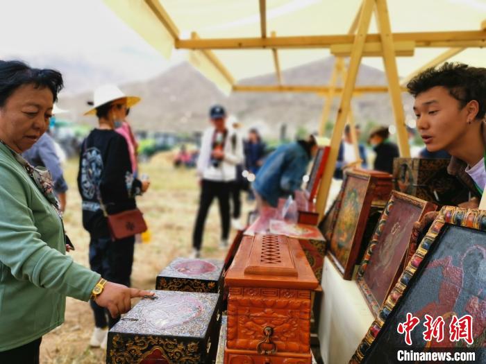 圖為拉薩市民在特色農畜產品展示展銷會上選購商品?！垈?攝
