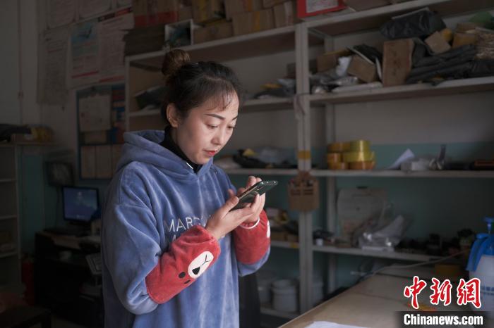 正在快遞站點內(nèi)忙碌的楊莉春?！『闻罾?攝