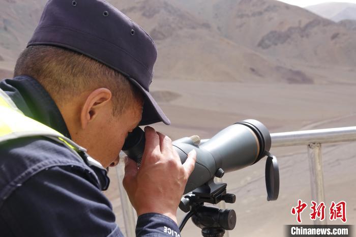 索朗曲扎用望遠(yuǎn)鏡查看邊境情況。　冉文娟 攝