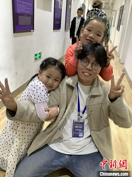 “Z世代”旦真旺加認為，拉薩是一座開放與包容的城市，記憶中的拉薩是彩色的。2021年，旦真旺加從浙江大學漢語言文學專業(yè)畢業(yè)后，他選擇回到拉薩，成為一名漢語文實習助教。圖為8月4日，旦真旺加在課間陪學生玩耍。 <a target='_blank' ><p  align=