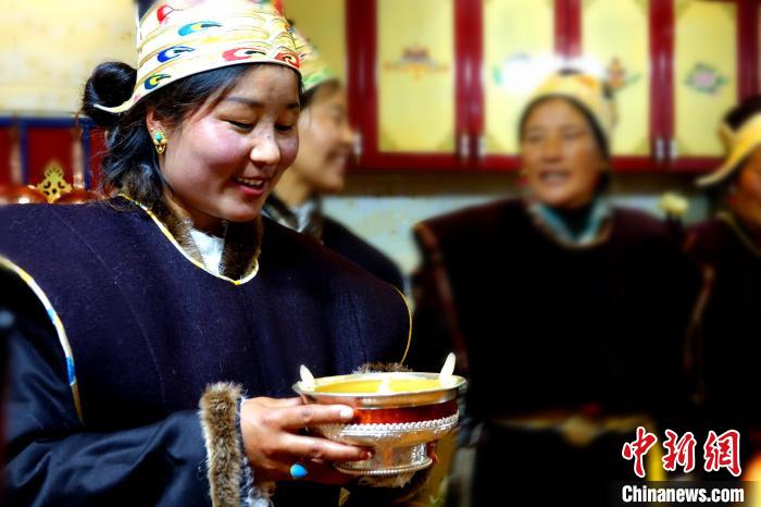 圖為藏族姑娘向客人敬酒?！∪轿木?攝