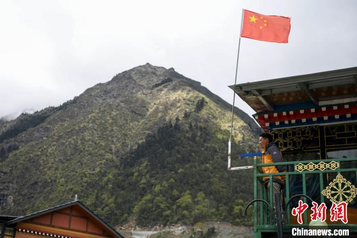 村民站在樓房上觀望?！钊A峰 攝