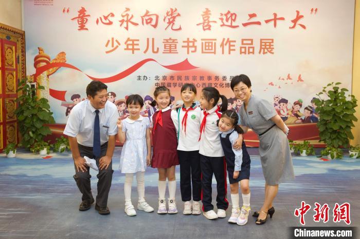 圖為與會(huì)嘉賓與入選畫(huà)作的“小作者”們?cè)谡褂[上合影?！≈袊?guó)藏學(xué)研究中心供圖