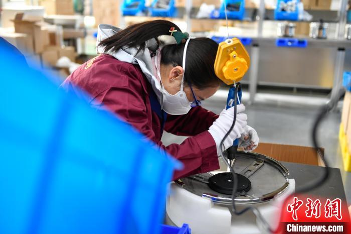 圖為工人正在組裝炊具?！∝暩聛硭?攝