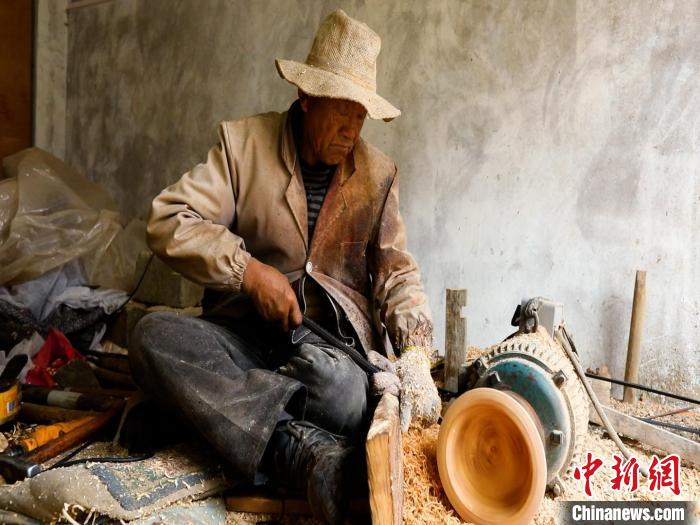 圖為手工藝人正在制作木碗?！?鄧海平 攝