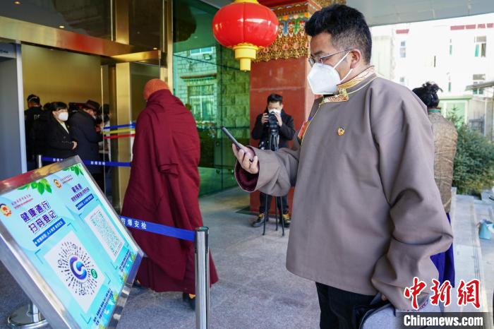 圖為政協(xié)委員掃場(chǎng)所碼進(jìn)入會(huì)場(chǎng)?！〗w波 攝