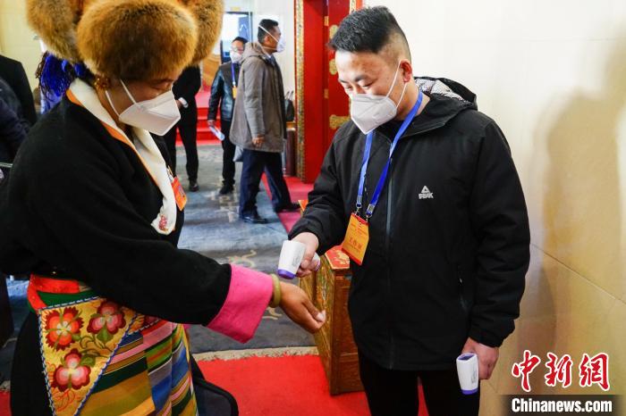 政協(xié)委員測(cè)體溫后入場(chǎng)?！〗w波 攝