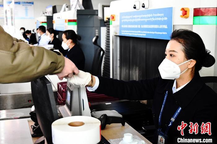 圖為機(jī)場(chǎng)工作人員為旅客辦理行李托運(yùn)?！≈芎?攝