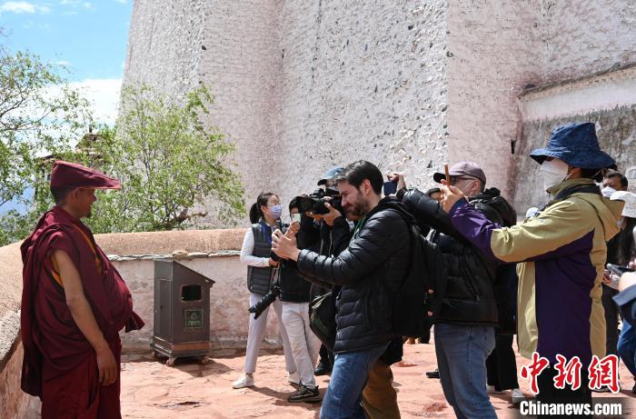 圖為中外媒體拍攝朝拜布達(dá)拉宮的僧人?！≮w朗 攝