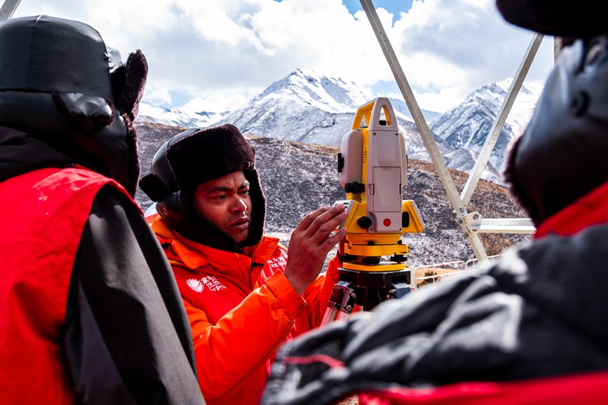 2023年11月30日，西藏自治區(qū)那曲市索縣榮布至丁青縣巴達(dá)35千伏線路工程負(fù)責(zé)人黃小洪（左二）現(xiàn)場(chǎng)開展線路弧測(cè)量教學(xué)。趙清鵬攝