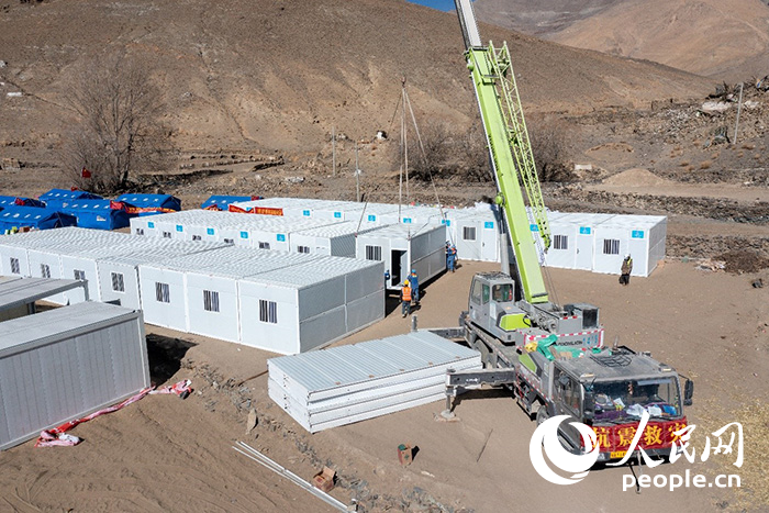 1月9日，在日喀則市定日縣長(zhǎng)所鄉(xiāng)古榮村安置點(diǎn)，救援人員和施工人員合力抓緊搭建移動(dòng)板房，確保受災(zāi)群眾溫暖過(guò)冬。人民網(wǎng)記者 翁奇羽攝
