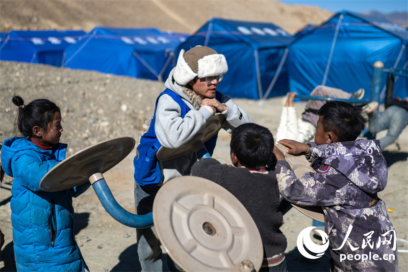 西藏星光社會(huì)工作服務(wù)中心社工久米旦增通過(guò)聊天談心，對(duì)孩子們進(jìn)行災(zāi)后心理疏導(dǎo)。人民網(wǎng)記者 翁奇羽攝
