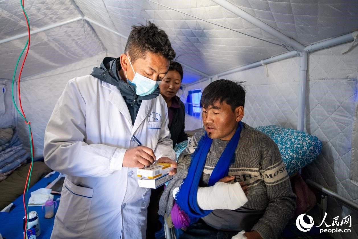 　醫(yī)生正在囑咐洛桑堅參如何用藥。人民網(wǎng)記者 翁奇羽攝