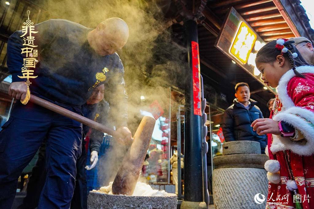 2025年1月29日，浙江省寧波市江北區(qū)慈城古縣城，市民和游客觀看搗年糕。人民網(wǎng) 章勇濤攝