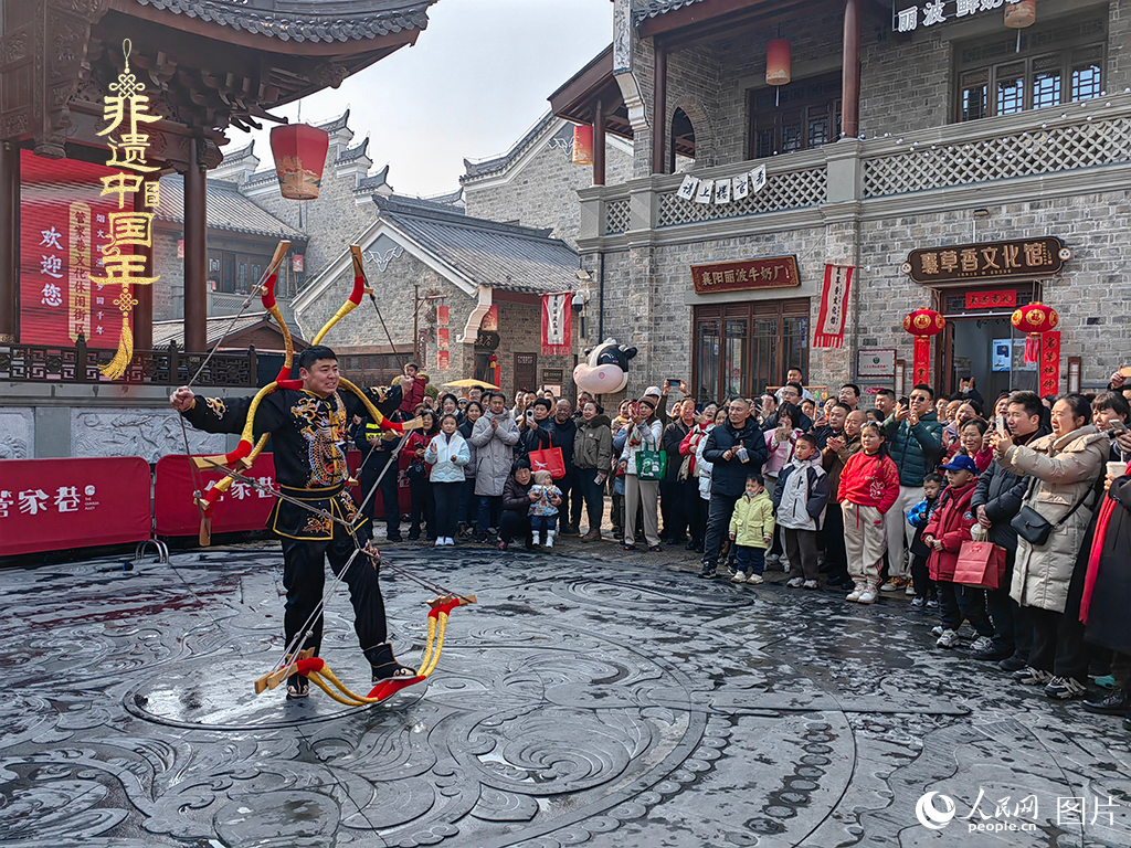 2025年1月29日，湖北襄陽市管家巷，老北京天橋大刀張舉大刀拉硬弓第五代傳承人現(xiàn)場表演，一次拉開6張弓，引來游客喝彩。人民網(wǎng)記者 郭婷婷攝