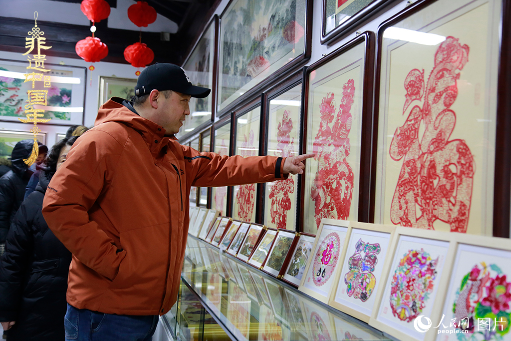 2025年1月23日，游客在天津楊柳青古鎮(zhèn)欣賞傳統(tǒng)剪紙作品，感受指尖上的古老藝術(shù)。人民網(wǎng)記者 崔新耀攝