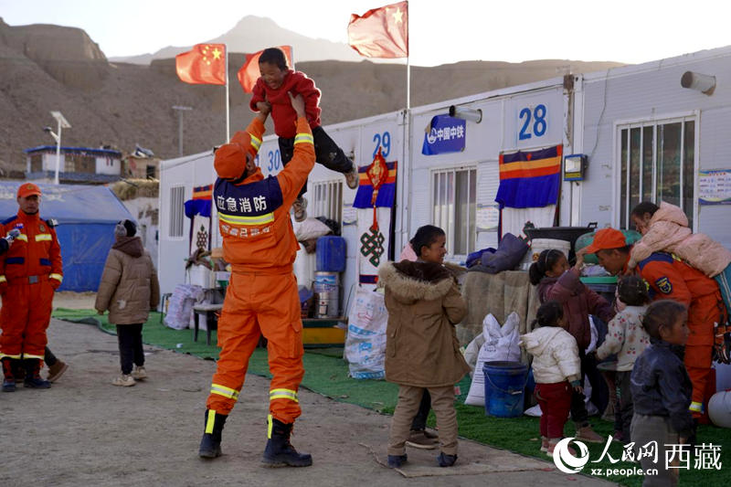 熱木青村安置點(diǎn)，消防員們同孩子們嬉戲玩耍。人民網(wǎng)記者 次仁羅布攝