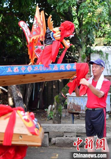 圖為5月29日，長樂江田鎮(zhèn)村民為即將入水的新龍舟系紅布?！埍?攝