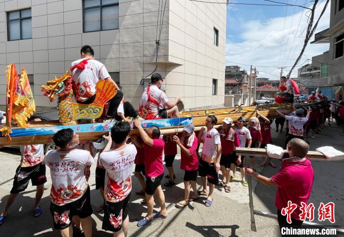 圖為5月29日，長樂江田鎮(zhèn)村民們肩扛著新龍舟舉行入水前游街儀式?！埍?攝