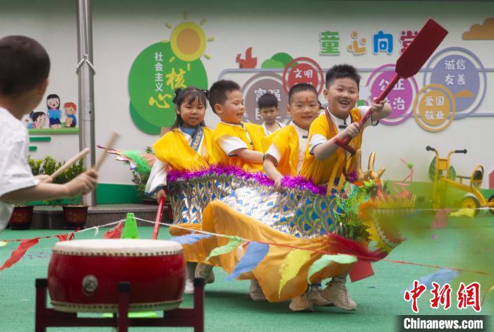 圖為龍舟賽游戲上，小伙伴們打鼓加油?！《^生 攝