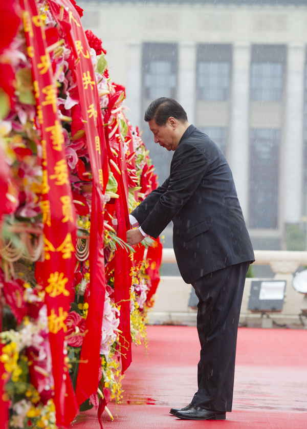 2013年10月1日上午，在首都各界代表向人民英雄紀(jì)念碑敬獻(xiàn)花籃儀式上，習(xí)近平整理花籃上的緞帶。